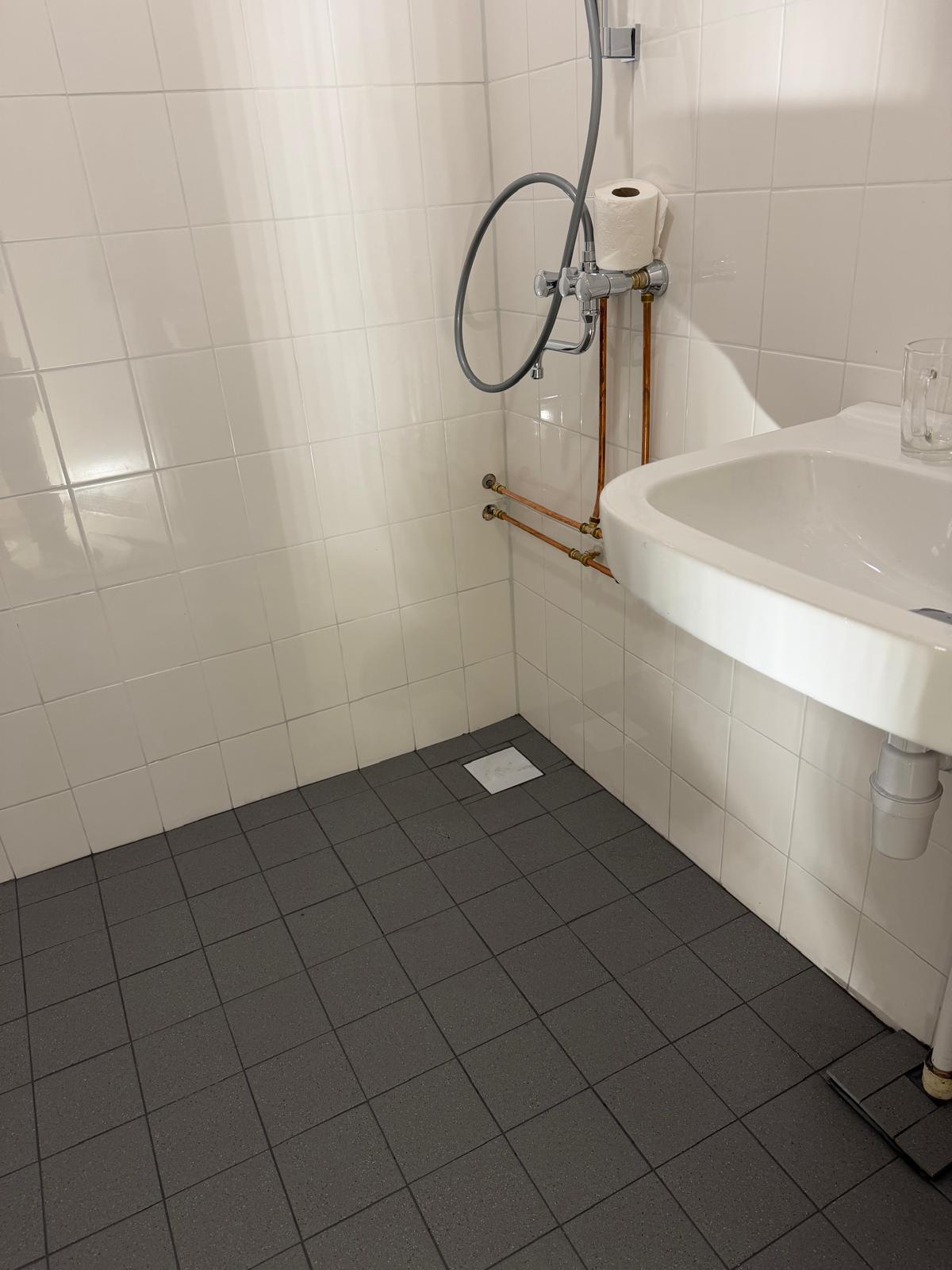 Finished bathroom with new tiling, shower and sink, tiling job by Klussen Fixer
